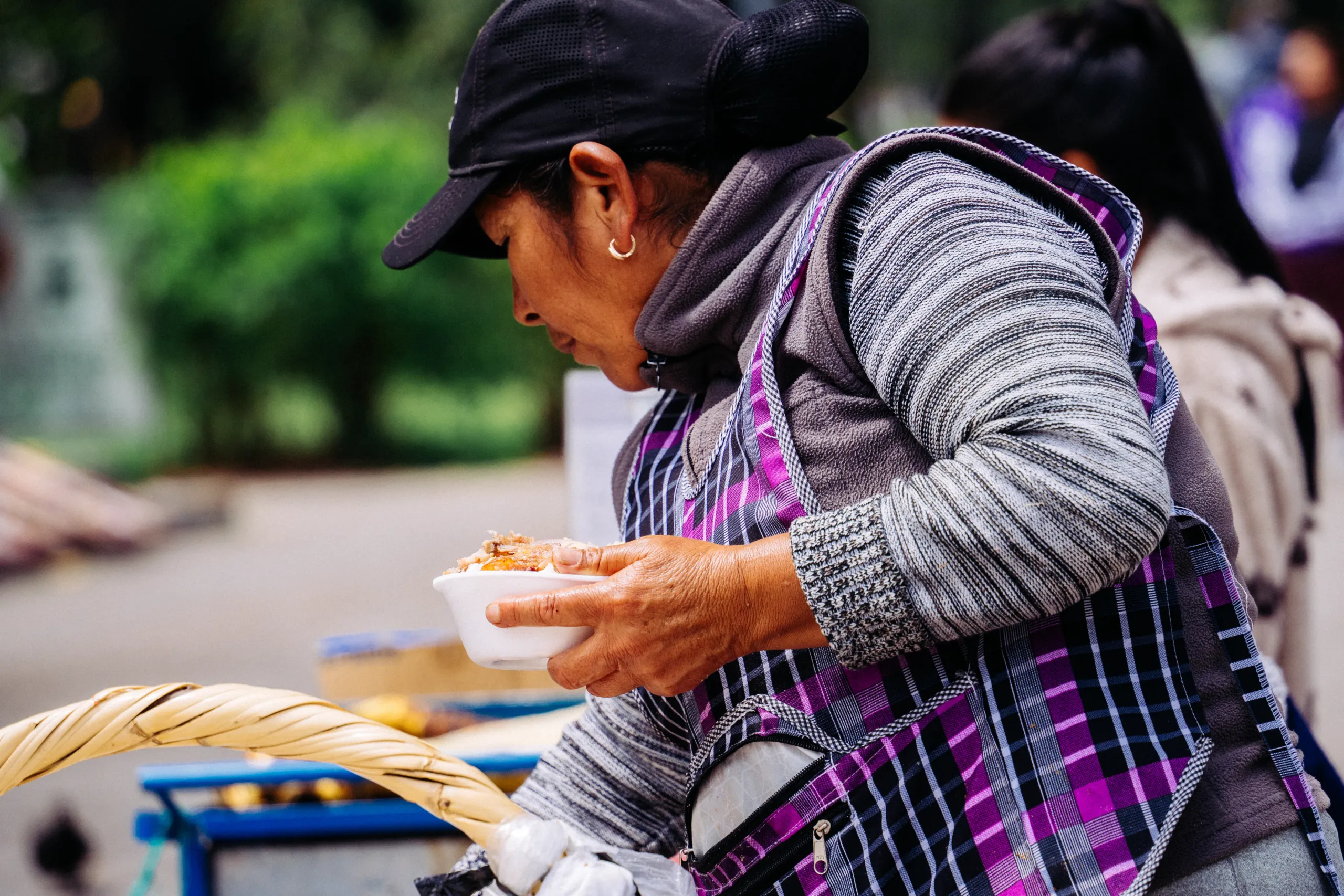 Una vendedora sirve un poco de horno en una tarrina de espumaflex en el parque El Ejido Una vendedora sirve un poco de horno en una tarrina de espumaflex en el parque El Ejido