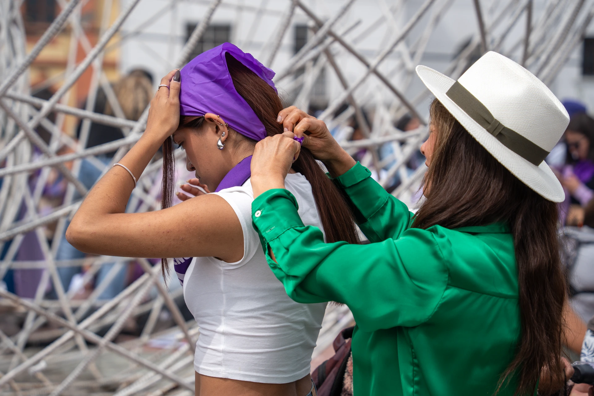 Una mujer ata el pañuelo de otra el 8 de marzo en Quito Una mujer ata el pañuelo de otra el 8 de marzo en Quito