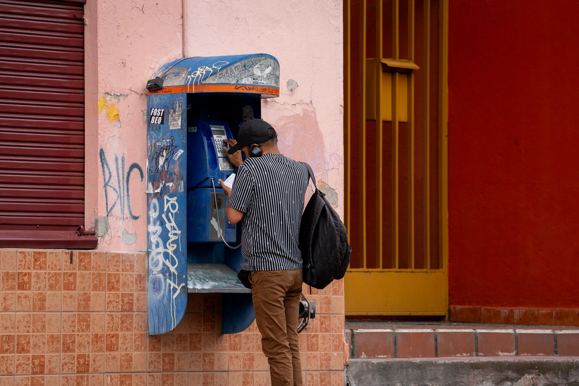 un hombre haciendo una llamada mientras usa su libretita de papel