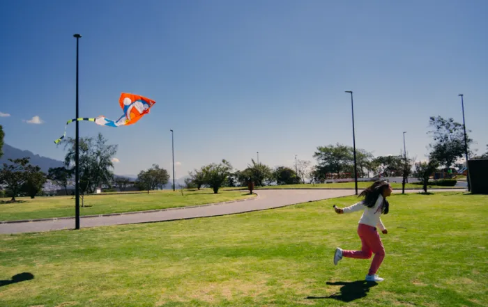 Una niña vuela una cometa en el parque en Quito