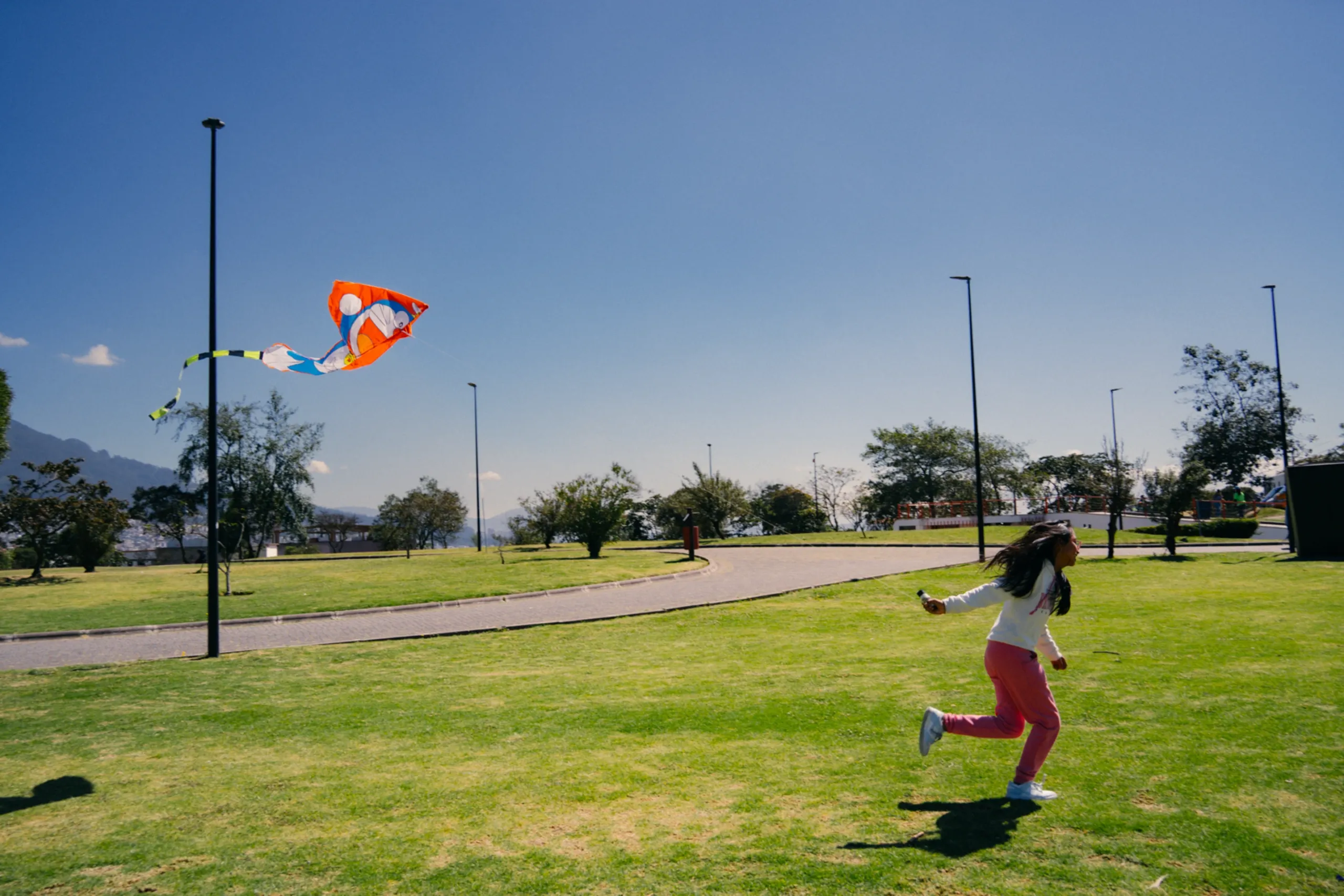 Una niña vuela una cometa en el parque en Quito