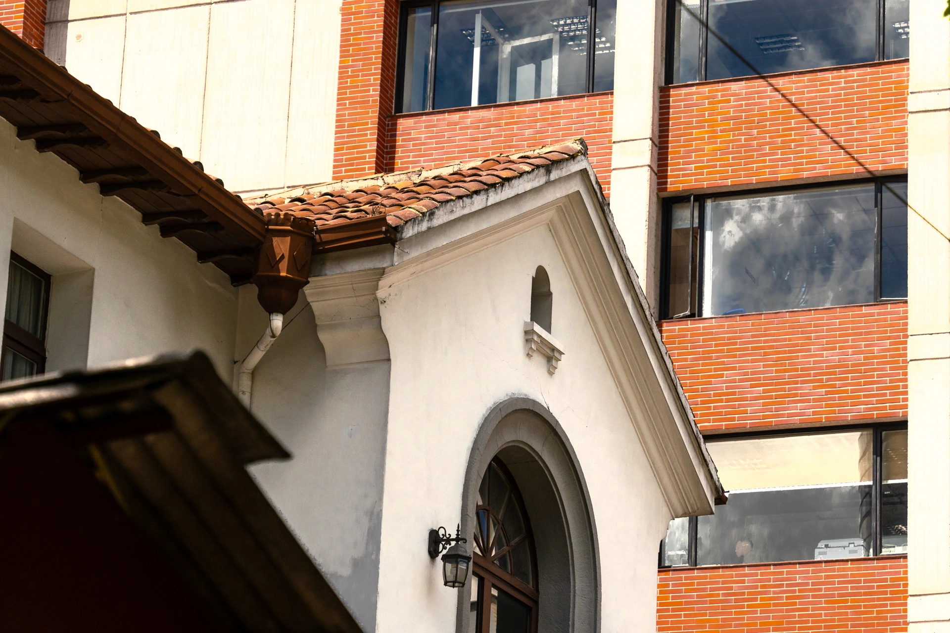 El detalle de un edificio moderno frente a una casa patrimonial en la av. 12 de Octubre