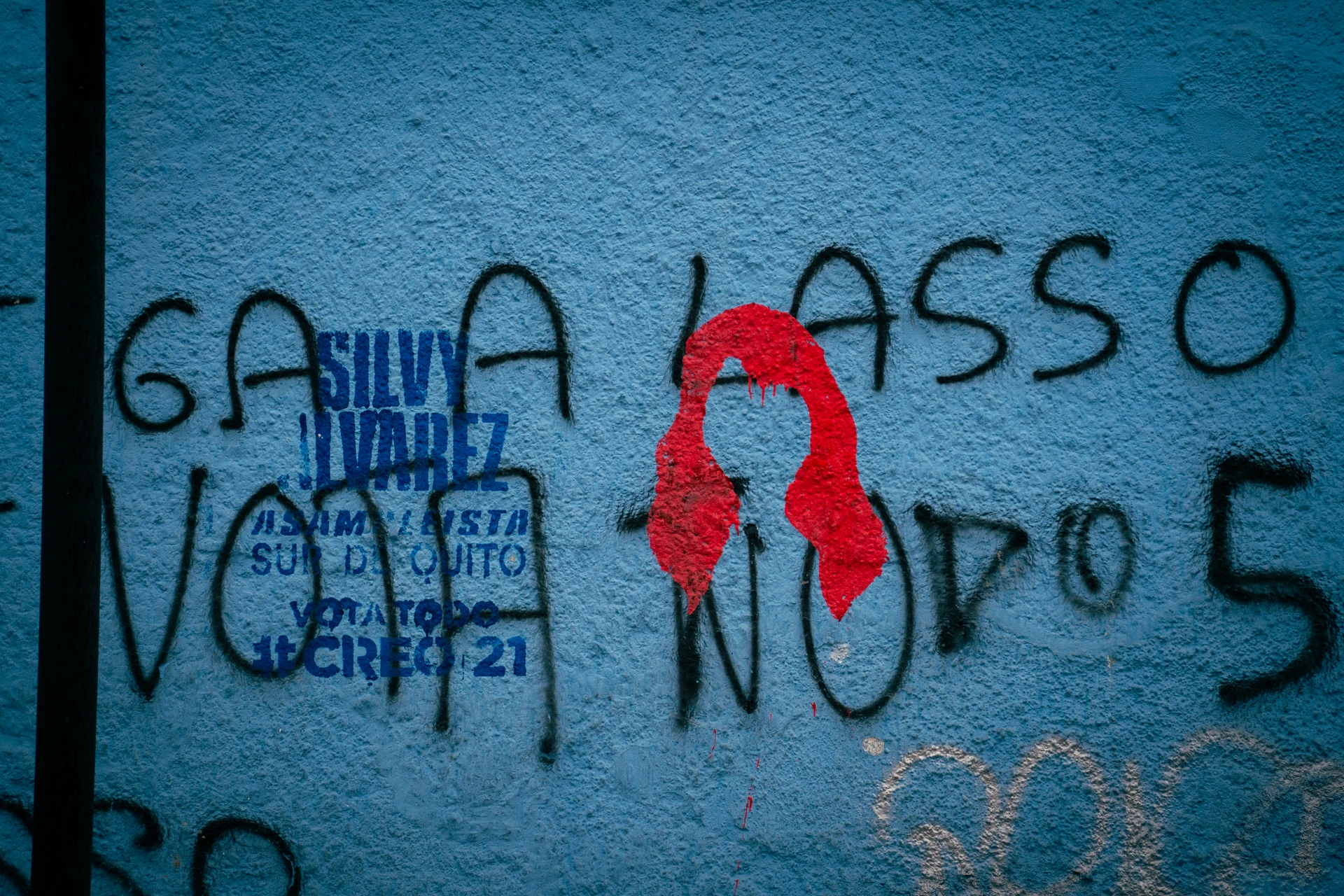 En una pared de Quito, los anuncios políticos se mezclan con grafitis de rechazo