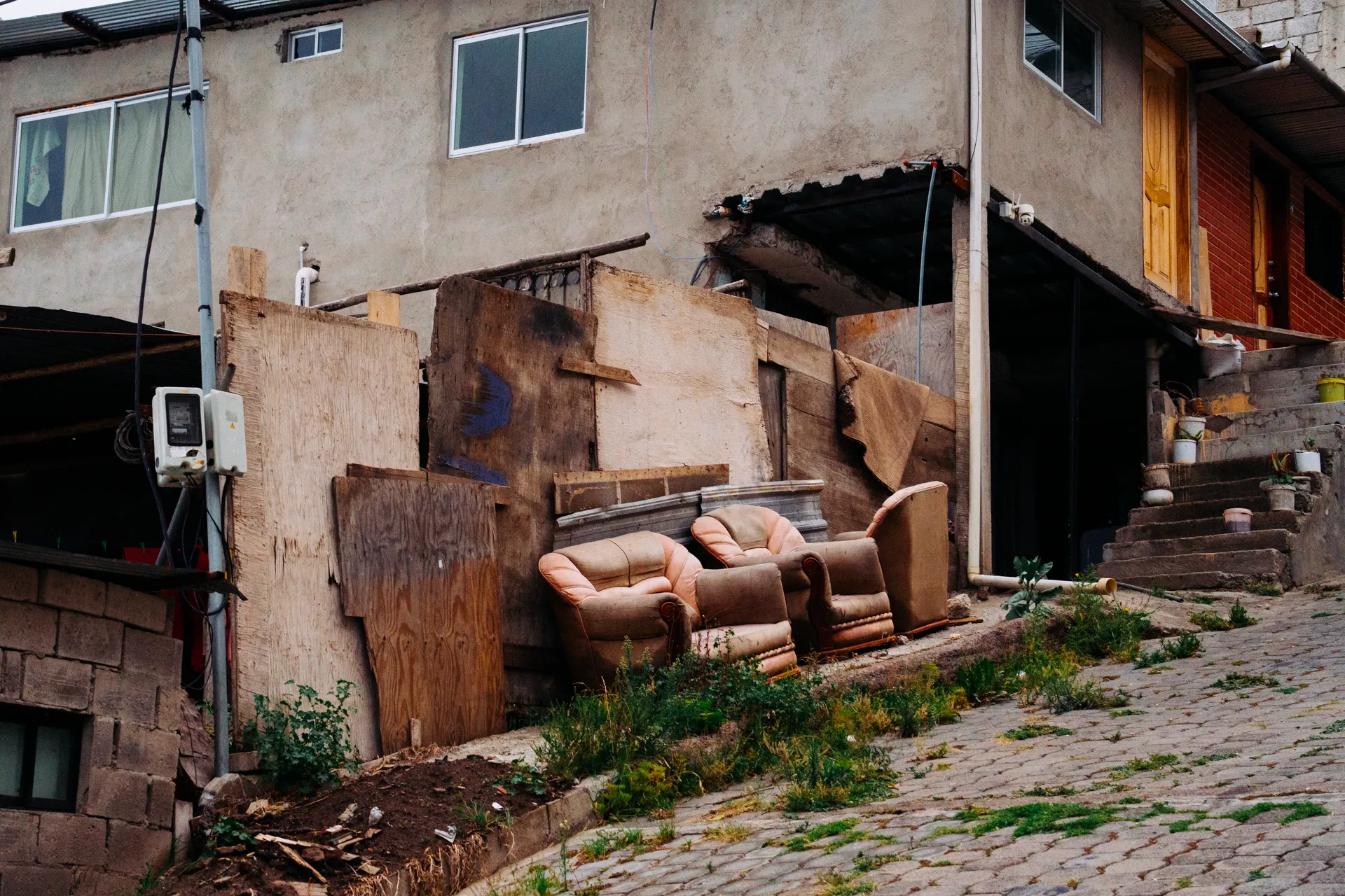 En la acera afuera de una casa dos sillones están abandonados En la acera afuera de una casa dos sillones están abandonados