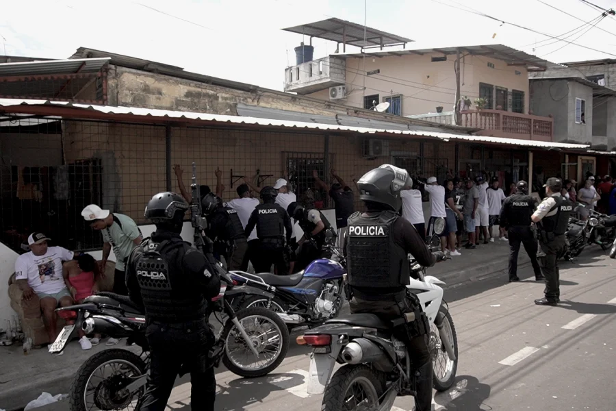 Policías requisan a ciudadanos que participan del velorio de un joven baleado en altamar, en Puerto Bolívar, Machala, provincia de El Oro. Foto: Mongabay Latam