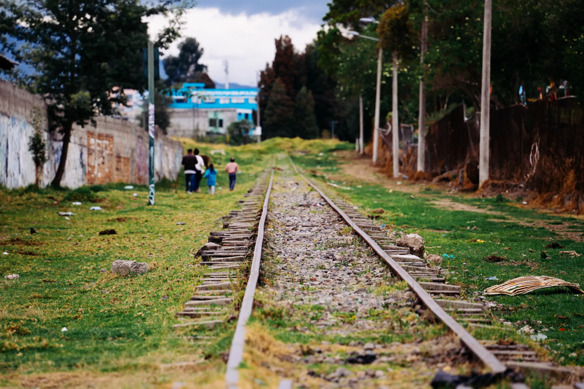 Una familia avanza a la vera de la riel del tren