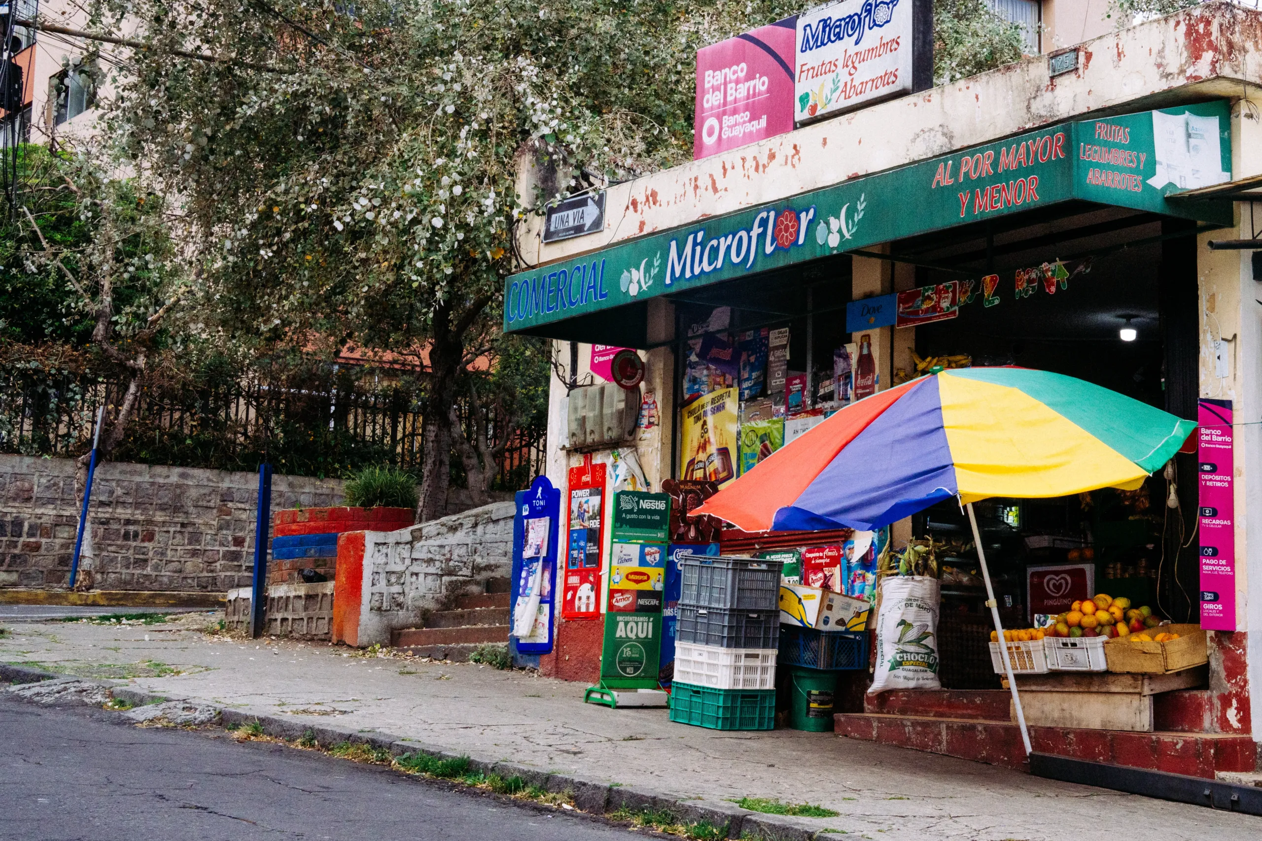 No hay barrio sin tienda, y no suele haber tienda sin toldo multicolor