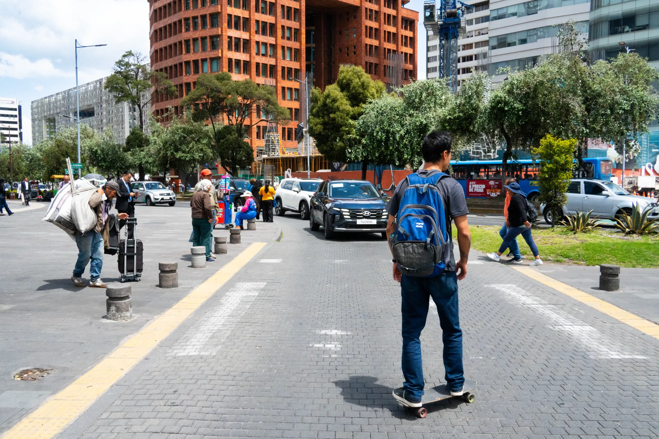 Un hombre en patineta en Quito trata de cruzar un paso peatonal